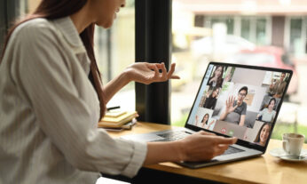 Woman participating using her laptop in an online discussion with a diverse group people of different genders and races